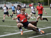 Cruz Williams of the Camas Rugby Club is tackled during a match against Budd Bay of Olympia at Doc Harris Stadium in Camas on Saturday, April 13, 2024.