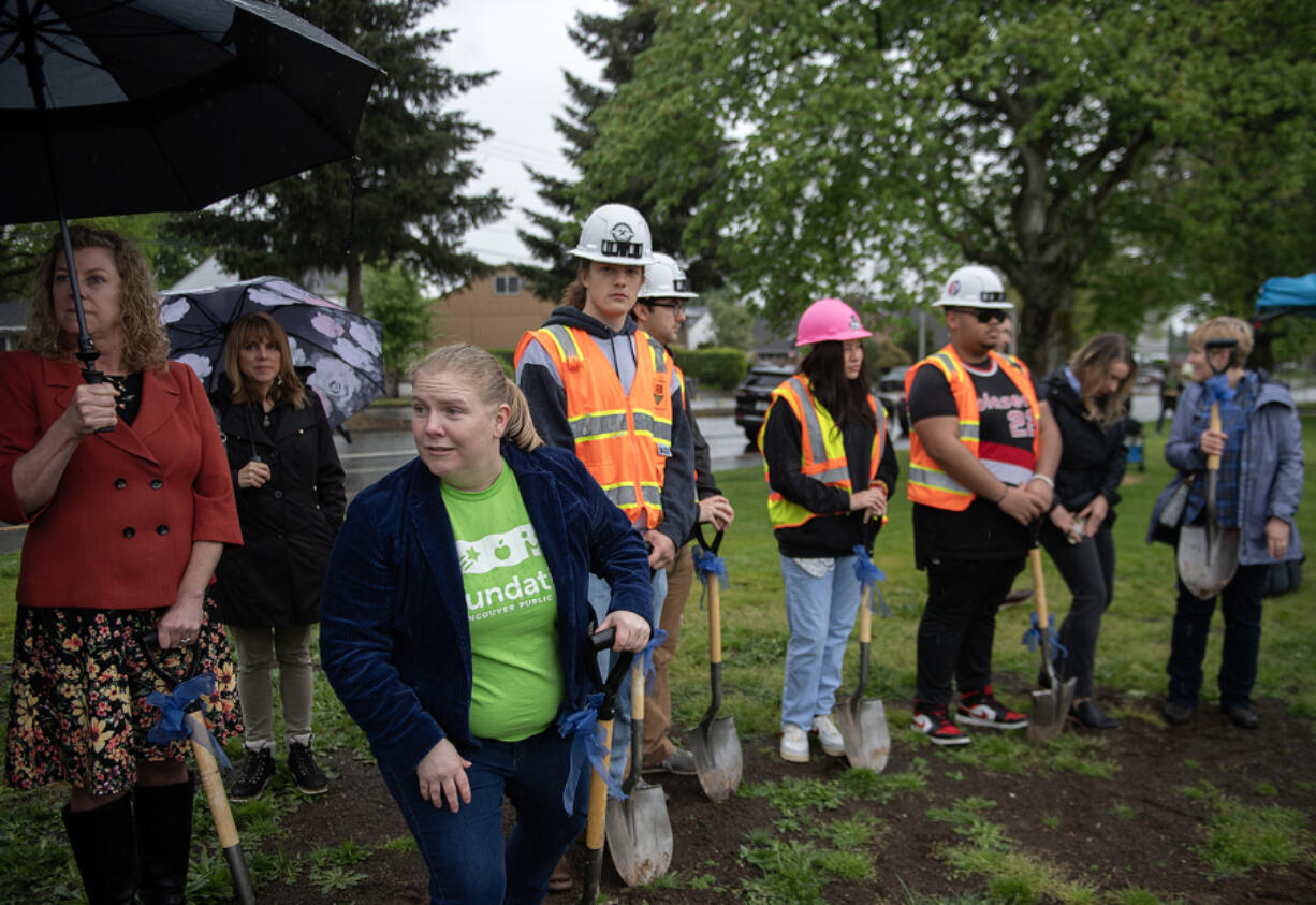 Jenny Thompson, executive director of the Foundation for Vancouver Public Schools, blue blazer, takes part in the groundbreaking on a new building to support construction trades and maritime pathways for Vancouver students at Hudson's Bay High School on Tuesday morning.