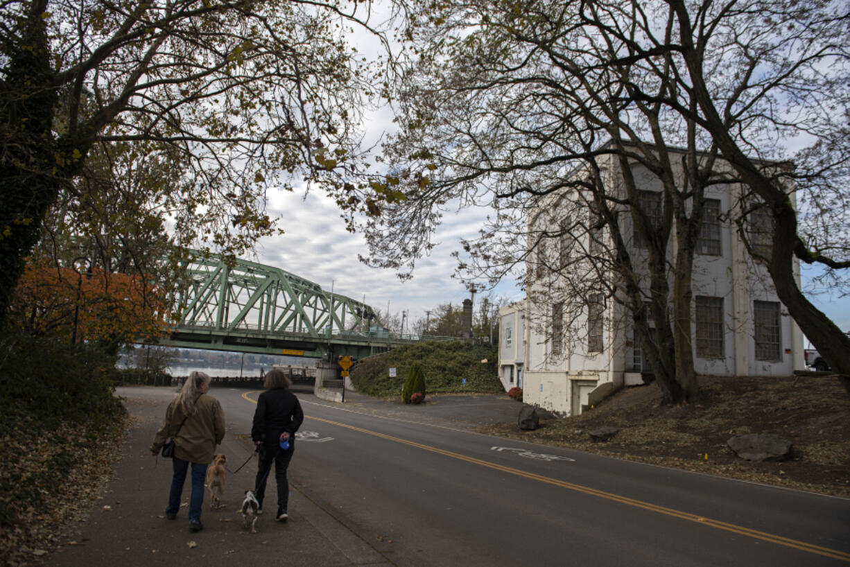 Pedestrians pass the old electrical substation at the foot of the northbound span of the Interstate 5 Bridge. The empty building is listed for sale at $1 million.