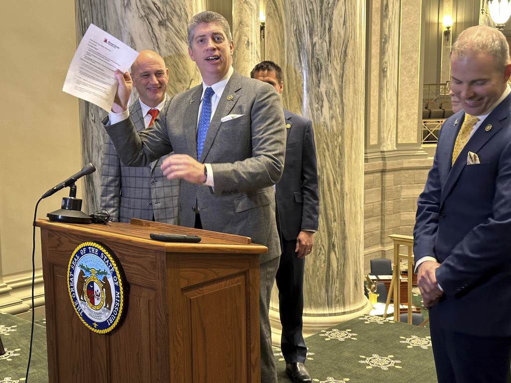 Missouri state Sen. Bill Eigel, a Republican member of the state Freedom Caucus, waives a paper containing criticisms of the Freedom Caucus that had been prepared by Republican Senate leaders for a press conference on Thursday, Jan. 25, 2024, at the state Capitol in Jefferson City, Mo. Republican leaders had left the paper on a lectern which the Freedom Caucus then used for its own press conference. (AP Photo/David A.