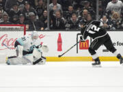 Los Angeles Kings left wing Trevor Moore, right, scores on Seattle Kraken goaltender Philipp Grubauer during the third period of an NHL hockey game Wednesday, April 3, 2024, in Los Angeles. That was Moore's third goal of the game. (AP Photo/Mark J.