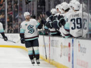 Seattle Kraken center Shane Wright, center left, celebrates after his goal with the bench during the first period of an NHL hockey game against the Anaheim Ducks, Friday, April 5, 2024, in Anaheim, Calif.