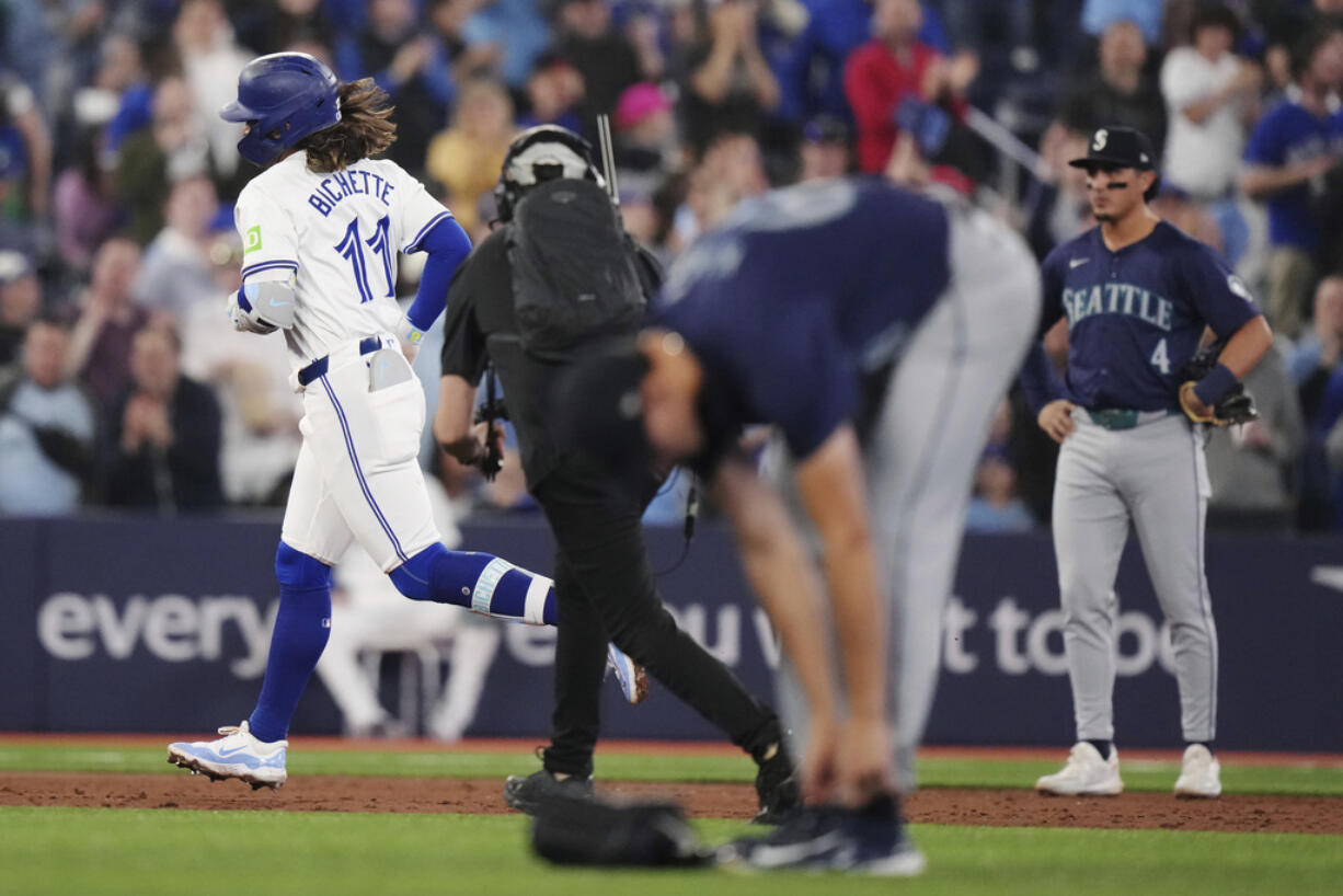 Toronto Blue Jays' Bo Bichette (11) runs the bases after hitting a two-run home run off Seattle Mariners pitcher George Kirby, foreground, during the third inning of a baseball game Tuesday, April 9, 2024, in Toronto.