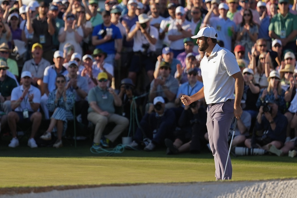 Scottie Scheffler celebrates after a birdie on the 18th hole during third round at the Masters golf tournament at Augusta National Golf Club Saturday, April 13, 2024, in Augusta, Ga.