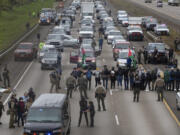 Anti- Israel protesters are detained as they block the southbound lane of Interstate 5 under the Harlow overpass between Eugene, Ore., and Springfield on Monday, April 15, 2024.