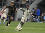 Portland Timbers midfielder Santiago Moreno (30) dribbles the ball past Los Angeles FC midfielder Timothy Tillman  during the second half of an MLS soccer match Saturday, April 27, 2024, in Los Angeles.