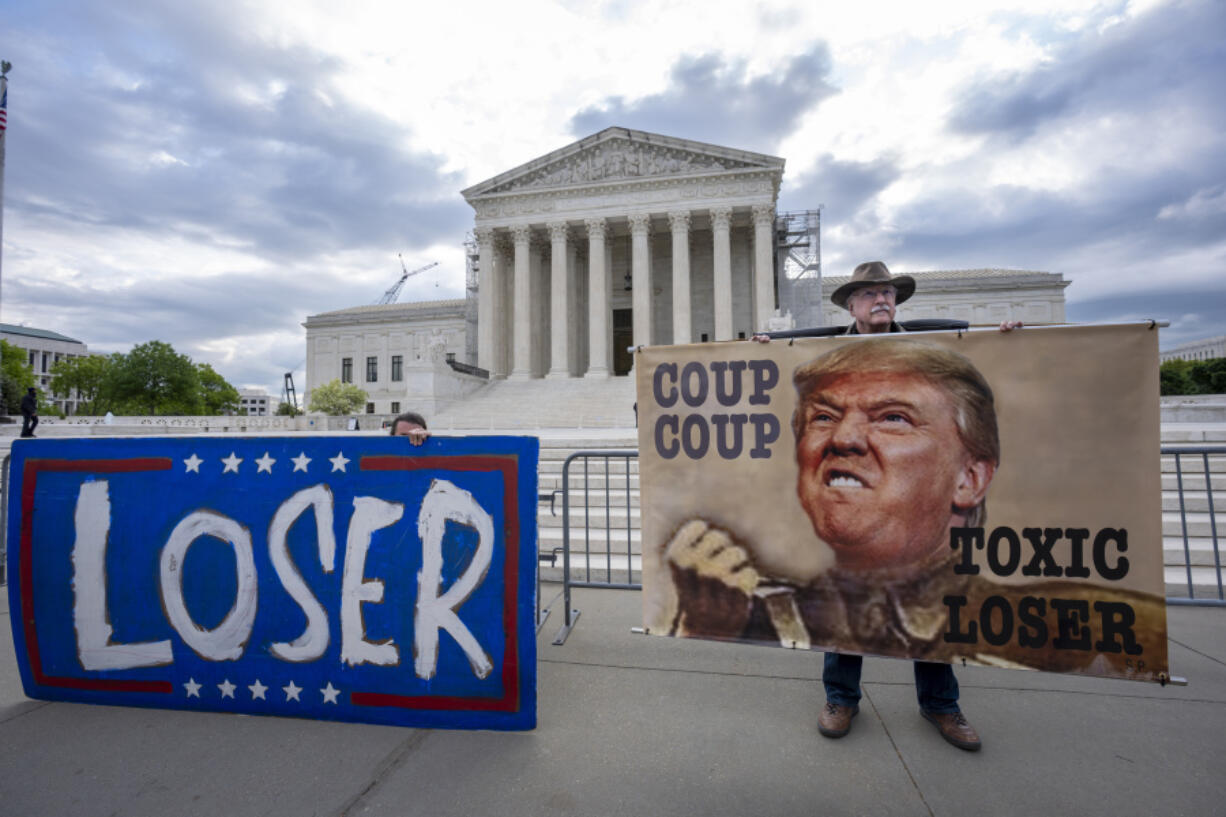 Activist Stephen Parlato of Boulder, Colo., right, joins other protesters outside the Supreme Court as the justices prepare to hear arguments over whether Donald Trump is immune from prosecution in a case charging him with plotting to overturn the results of the 2020 presidential election, on Capitol Hill in Washington, Thursday, April 25, 2024. (AP Photo/J.