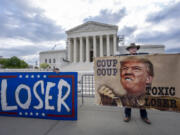 Activist Stephen Parlato of Boulder, Colo., right, joins other protesters outside the Supreme Court as the justices prepare to hear arguments over whether Donald Trump is immune from prosecution in a case charging him with plotting to overturn the results of the 2020 presidential election, on Capitol Hill in Washington, Thursday, April 25, 2024. (AP Photo/J.