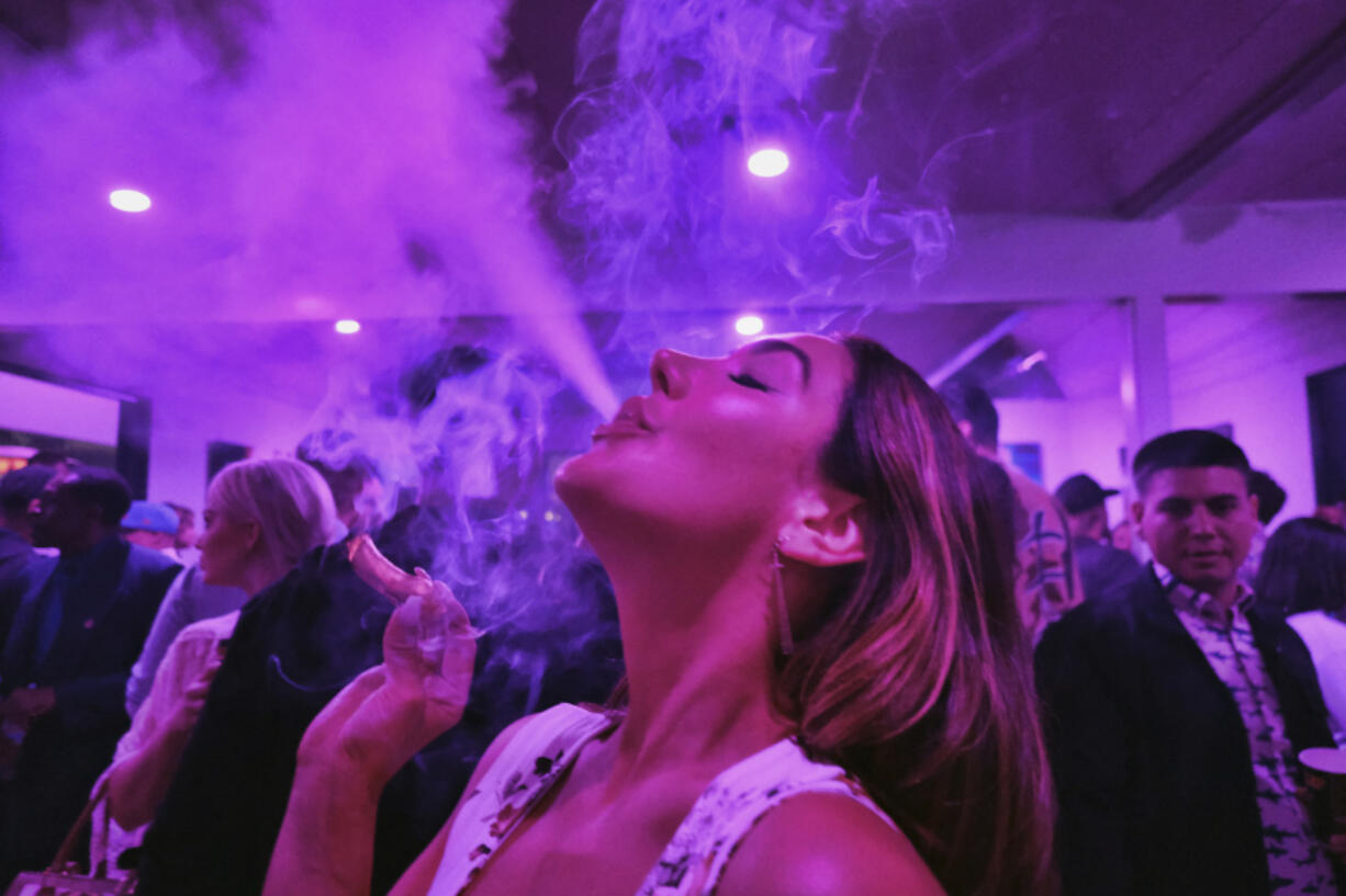 FILE - A guest takes a puff from a marijuana cigarette at the Sensi Magazine party celebrating the 420 holiday in the Bel Air section of Los Angeles, April 20, 2019. Marijuana advocates are gearing up for Saturday, April 20, 2024. Known as 4/20, marijuana&#039;s high holiday is marked by large crowds gathering in parks, at festivals and on college campuses to smoke together. This year, activists can reflect on how far the movement has come.