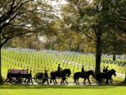 FILE - A U.S. Army Caisson team carries the remains of Army Pfc. Tramaine J. Billingsley during burial services at Arlington National Cemetery in Arlington, Va., Nov. 2, 2010. The return of horse-drawn caissons at Arlington National Cemetery is being delayed for at least months or a year, the Army said Friday, April 12, 2024, as officials struggle to improve the care of the horses, after two died in 2022 as a result of poor feed and abysmal living conditions.