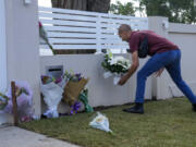 A man places flowers outside the Christ the Good Shepherd church in suburban Wakely in western Sydney, Australia, Tuesday, April 16, 2024. Australian police say a knife attack in Sydney that wounded a bishop and a priest during a church service as horrified worshippers watched online and in person, and sparked a riot was an act of terrorism.