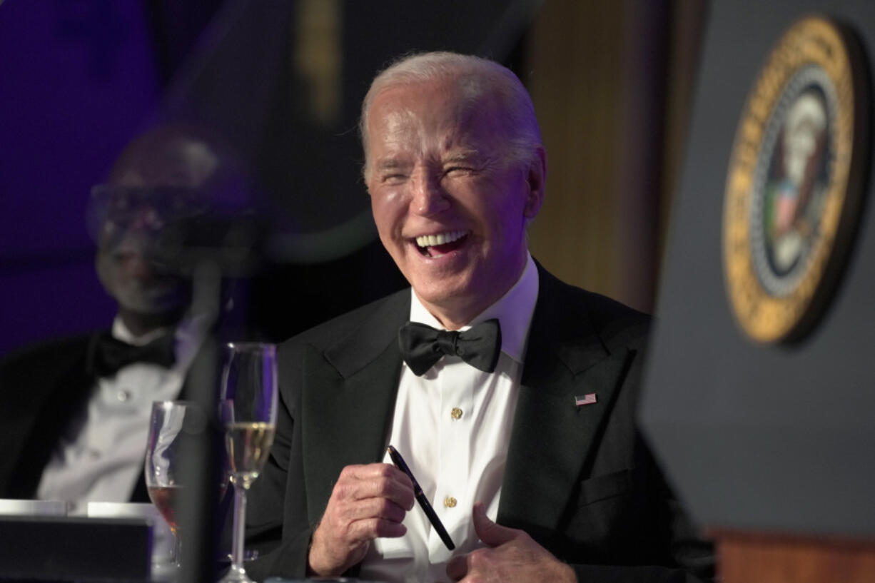 President Joe Biden laughs as host Colin Jost speaks at the White House Correspondents&rsquo; Association Dinner at the Washington Hilton, Saturday, April 27, 2024, in Washington.