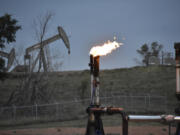 FILE - A flare to burn methane from oil production is seen on a well pad near Watford City, N.D., on Aug. 26, 2021. Oil and gas companies will have to pay more to drill on public lands and satisfy stronger requirements to clean up old or abandoned wells under a final rule issued Friday, April 12, 2024, by the Biden administration. The Interior Department rule does not go so far as to prohibit new oil and gas leasing on public lands, as many environmental groups have urged and as President Joe Biden promised during the 2020 campaign.