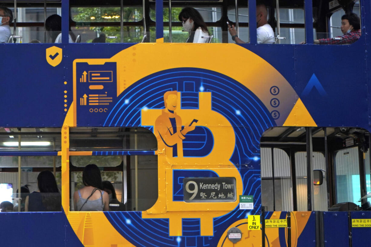 FILE - An advertisement for the cryptocurrency Bitcoin displayed on a tram, May 12, 2021, in Hong Kong. Sometime in the next few days or even hours, the &ldquo;miners&rdquo; who chisel bitcoins out of complex mathematics are going to take a 50% pay cut &mdash; effectively slicing new emissions of the world&rsquo;s largest cryptocurrency in an event called bitcoin halving.