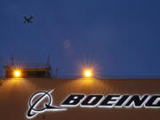 FILE - An airplane flies over a sign on Boeing&rsquo;s 737 delivery center, Oct. 19, 2015, at Boeing Field in Seattle. The Federal Aviation Administration says a Southwest Airlines jet leaving Denver was forced to land after the engine cover fell off and struck the wing flap during takeoff. Southwest Airlines says the Boeing 737 landed safely Sunday, April 7, 2024, and the passengers headed to Houston are being put onto another aircraft.  (AP Photo/Ted S.