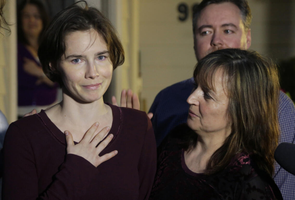 FILE - Amanda Knox, left, talks to reporters as her mother, Edda Mellas, right, looks on outside Mellas&#039; home in Seattle, Friday, March 27, 2015. Amanda Knox faces yet another trial for slander in a case that could remove the last remaining guilty verdict against her nine years after Italy&#039;s highest court definitively threw out her conviction for the murder of her 21-year-old British roommate, Meredith Kercher. (AP Photo/Ted S.