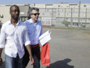 FILE - Rudy Guede, left, leaves the penitentiary for a temporary release of thirty-six hours, in Viterbo, Italy, on June 25, 2016. Guede, the only person convicted in the 2007 murder of British student Meredith Kercher has been freed after serving most of his 16-year prison sentence. Amanda Knox faces yet another trial for slander in a case that could remove the last remaining guilty verdict against her nine years after Italy&rsquo;s highest court definitively threw out her conviction for the murder of her 21-year-old British roommate, Meredith Kercher.