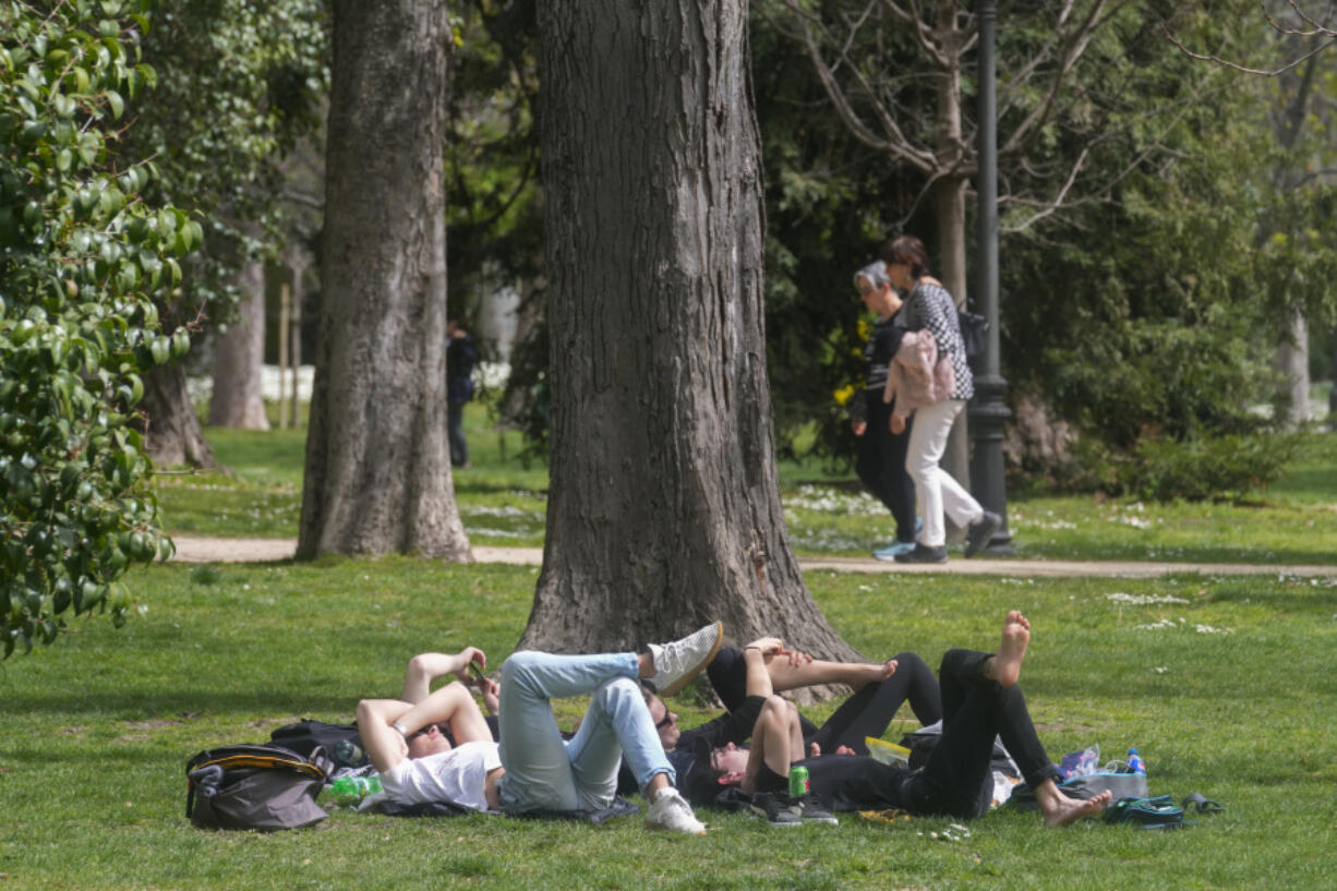 FILE - People relax in the Retiro park in Madrid, Spain, Wednesday, March 20, 2024. Copernicus has reported that March marked the 10th straight month of record monthly temperatures. Europe is the fastest-warming continent and its temperatures are rising at roughly twice the global average, two top climate monitoring organizations reported Monday, April 22, 2024, warning of the consequences for human health, glacier melt and economic activity.