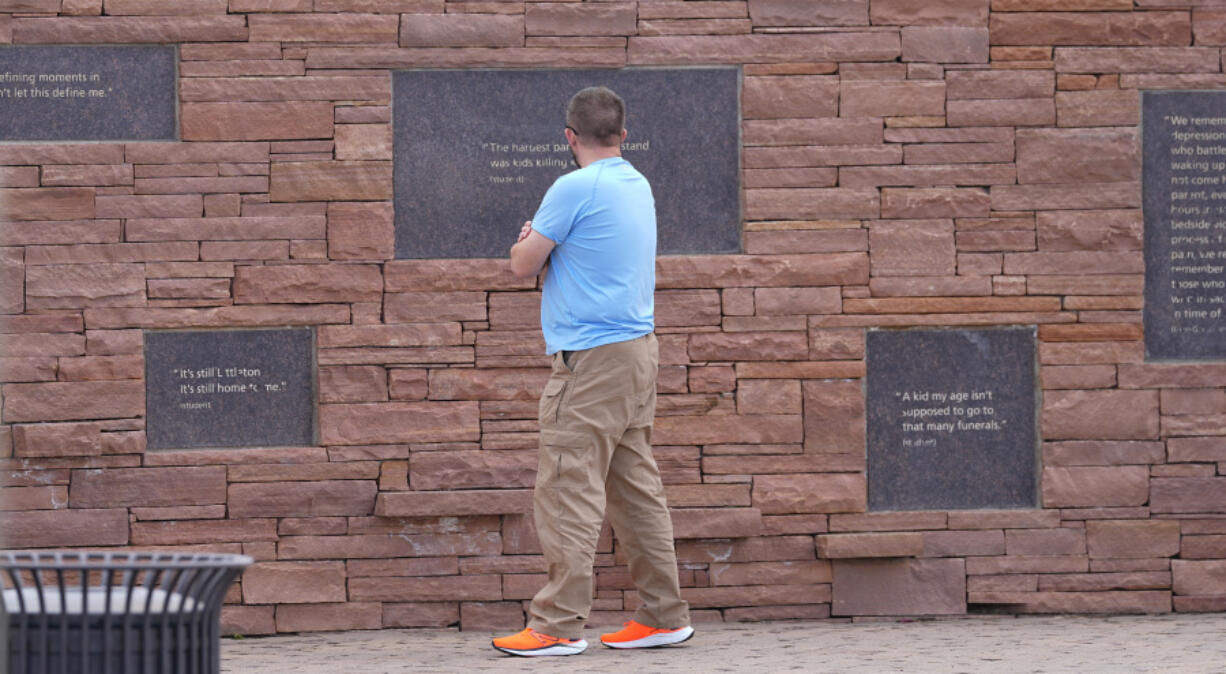 A visitor looks at the plaques on the wall of healing at the Columbine Memorial, Wednesday, in Littleton, Colo. Trauma still shadows the survivors of the horrific Columbine High School shooting as the attack&rsquo;s 25th anniversary approaches.