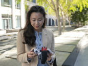 Content creator Cynthia Huang Wang edits work near the Embarcadero in San Francisco, Monday, April 8, 2024. Despite a strong job market, there are still thousands of people who have found themselves out of work across industries stretching from tech to retail to media. But rather than trying to find another job in their old role, some workers are turning to online content creation.