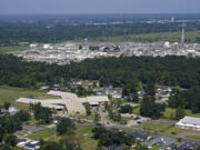 FILE - The Fifth Ward Elementary School and residential neighborhoods sit near the Denka Performance Elastomer Plant, back, in Reserve, La., Friday, Sept. 23, 2022. The Environmental Protection Agency on Tuesday, April 9, 2024, issued a rule that will force more than 200 chemical plants nationwide to reduce toxic compounds that cross beyond their property lines, exposing thousands of people to elevated cancer risks. The rule will significantly reduce harmful emissions at the Denka Performance Elastomer facility, the largest source of chloroprene emissions in the country, EPA Administrator Michael Regan said.