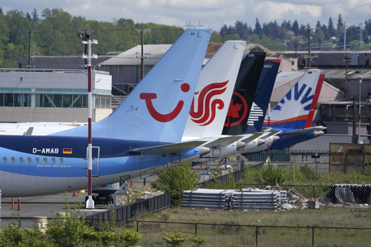 FILE - Boeing 737 Max airplanes, including one belonging to TUI Group, left, sit parked at a storage lot, Monday, April 26, 2021, near Boeing Field in Seattle.  Boeing reports earnings on Wednesday, April 24, 2024. (AP Photo/Ted S.