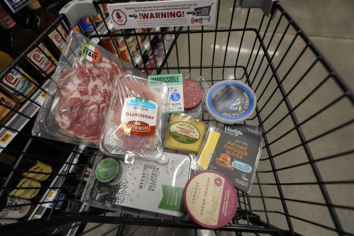 An assortment of vegan, organic, locally sourced, and wild caught food products all using plastic packaging, sit in a shopping cart at a grocery store in New Orleans, Wednesday, April 17, 2024. People are increasingly breathing, eating and drinking tiny particles of plastic, however, there are simple things people can do at the grocery store if they want to use less plastic.