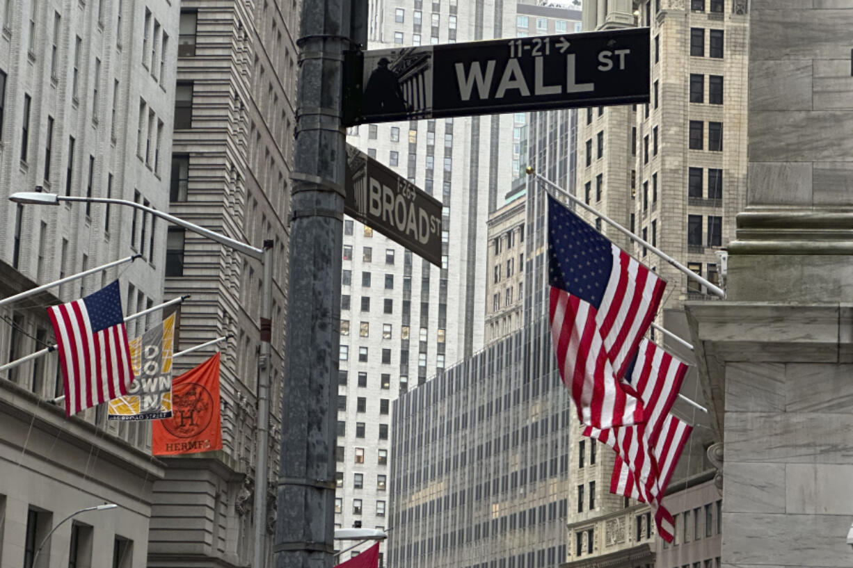 American flags hang from the front the New York Stock Exchange, right, on Thursday, April 11, 2024 in New York. Shares in Europe and Asia are mostly lower after U.S. stocks fell following another release of hotter than expected inflation data.