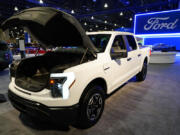 FILE - The Ford F-150 Lightning displayed at the Philadelphia Auto Show, Friday, Jan. 27, 2023, in Philadelphia.  With U.S. electric vehicle sales starting to slow, Ford Motor Co. says, Thursday, April 4, 2024,  it will delay rolling out new electric pickup trucks and a new large electric SUV as it adds gas-electric hybrids to its model lineup.