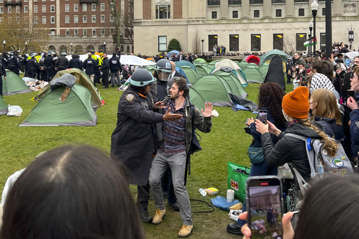 New York Police officers arrest a protestor who participated in an encampment on the Columbia University campus, Thursday, April 18, 2024, in New York. The protestors were calling for the school to divest from corporations profiting from the war in the Middle East.