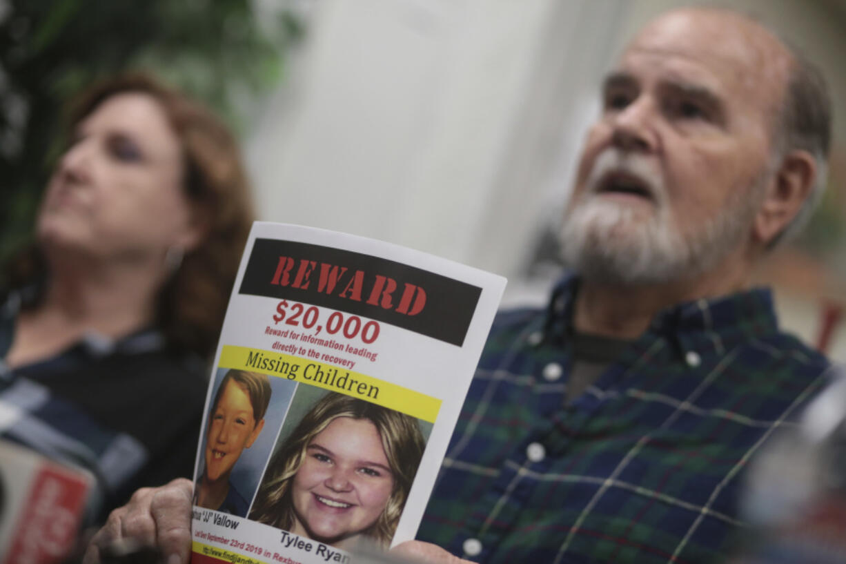 FILE - Larry Woodcock speaks to media members at the Rexburg Standard Journal Newspaper in Rexburg, Idaho on Jan. 7, 2020, while holding a reward flyer for Joshua Vallow and Tylee Ryan. A self-published doomsday fiction author is on trial in Idaho in the deaths of his wife and his new girlfriend&rsquo;s two children. Chad Daybell has pleaded not guilty to murder, conspiracy and grand theft charges in the deaths of his late wife Tammy Daybell, as well as the children, Joshua &ldquo;JJ&rdquo; Vallow and Tylee Ryan.