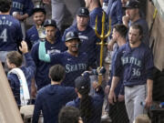 Seattle Mariners&#039; Julio Rodriguez holds a trident in the dugout after hitting a two-run home run against the Texas Rangers during the third inning of a baseball game in Arlington, Texas, Tuesday, April 23, 2024.