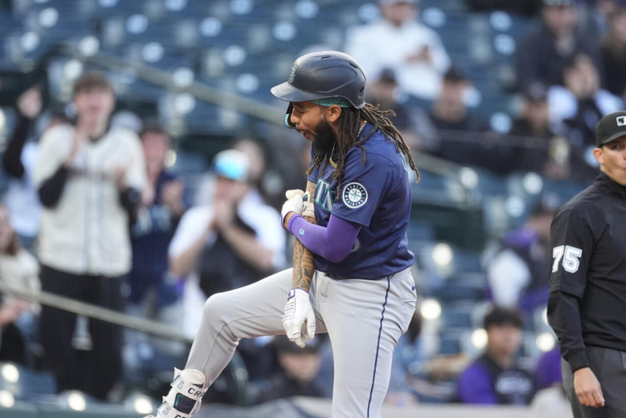 Seattle Mariners&#039; J.P. Crawford, left, reacts after reaching third base on a triple that drove in three runs off Colorado Rockies starting pitcher Peter Lambert in the second inning of the second game of a baseball doubleheader Sunday, April 21, 2024, in Denver.