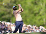 Scottie Scheffler watches his tee shot on the 12th hole during final round at the Masters golf tournament at Augusta National Golf Club Sunday, April 14, 2024, in Augusta, Ga.