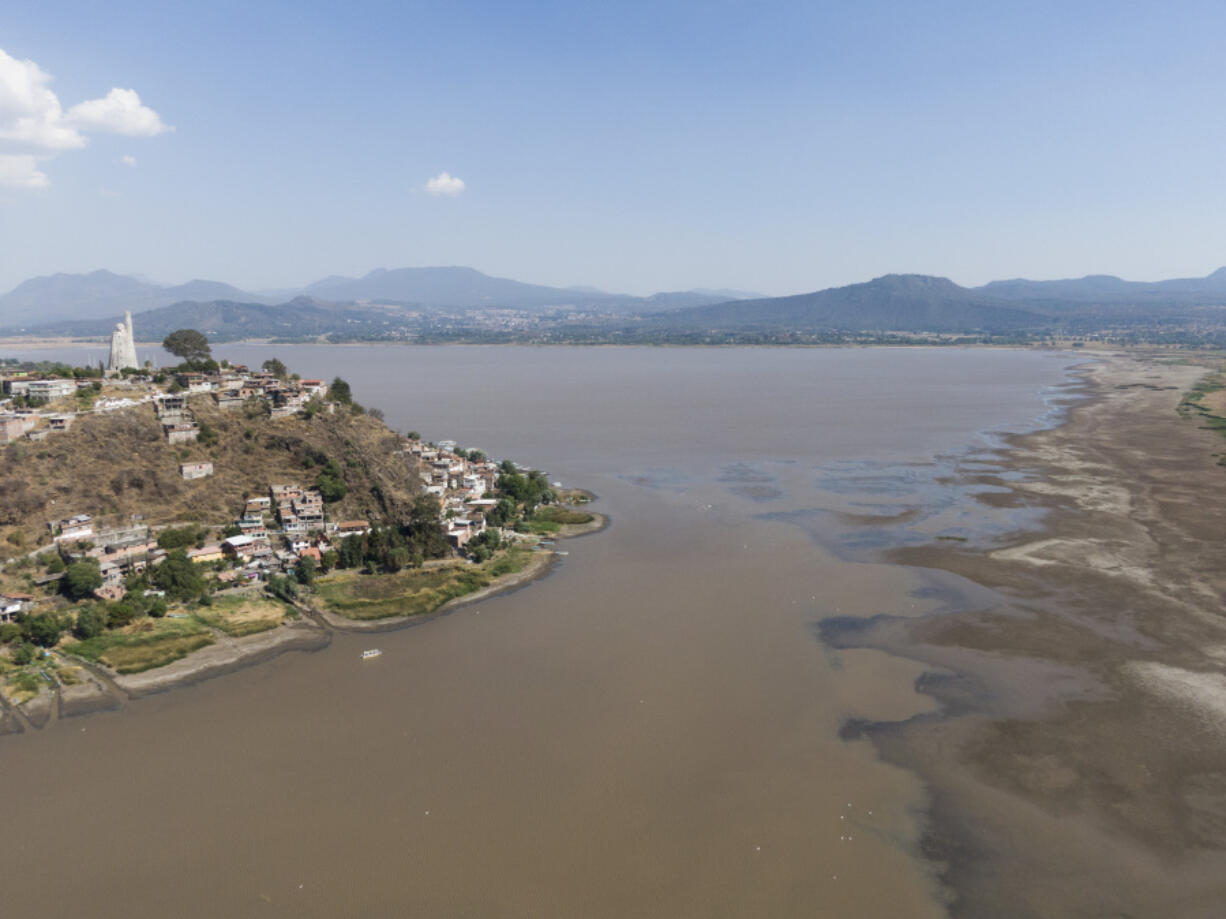 Janitzio Island stands in Lake Patzcuaro, which has low water levels during a drought in Mexico, Thursday, April 18, 2024. Farmers are starting to pasture livestock and plant crops on the lake bed.