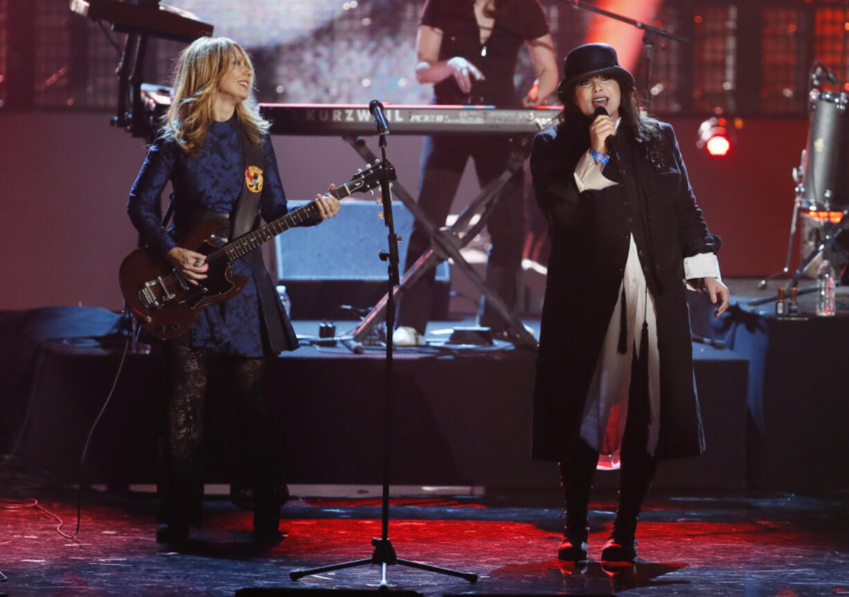 FILE - Nancy Wilson, left, and Ann Wilson, right, of the band Heart perform as Heart is inducted into the Rock and Roll Hall of Fame during the Rock and Roll Hall of Fame Induction Ceremony at the Nokia Theatre on Thursday, April 18, 2013 in Los Angeles.