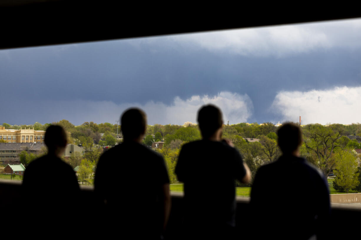 From left; Ally Mercer, Gabe Sedlacek Kaleb Andersen and Austin Young watch a tornado from a seventh floor parking garage on Friday, April 26, 2024, in Lincoln, Neb.