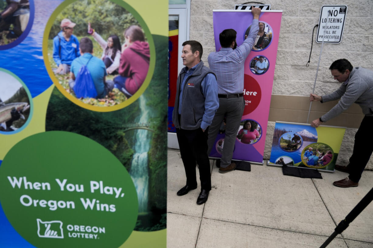 FILE - Plaid Pantry President and CEO Jonathan Polonsky speaks with a media member as Oregon Lottery signs are taken down after a news conference outside a Plaid Pantry convenience store on April 9, 2024, in Portland, Ore. Oregon authorities are set to reveal the winner of the $1.3 billion Powerball jackpot. The Oregon Lottery says it will identify the person Monday, April 29, 2024.