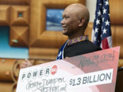 Cheng "Charlie" Saephan holds display check before speaking during a news conference where it was revealed that he was one of the winners of the $1.3 billion Powerball jackpot at the Oregon Lottery headquarters on Monday, April 29, 2024, in Salem, Ore.