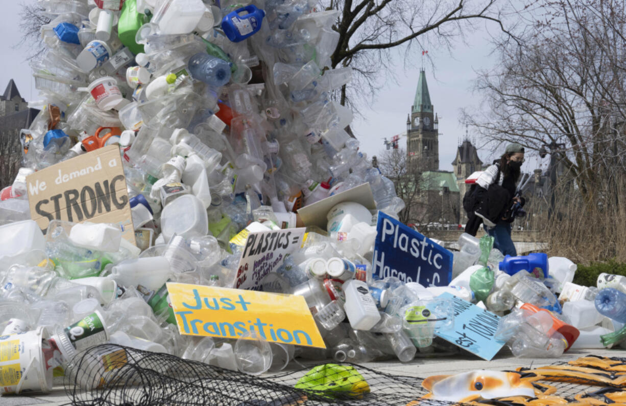 FILE - A person walks past an art installation outside a United Nations conference on plastics on April 23, 2024, in Ottawa, Ontario.