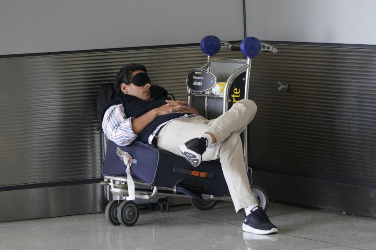 A traveler takes a nap as he waits for a ride outside Miami International Airport, Friday, July 1, 2022, in Miami. The Gallup survey, released Monday, April 15, 2024, says that a majority of Americans say they would feel better if they could have more sleep. But in the U.S., where the ethos of grinding and pulling yourself up by your own bootstraps is ubiquitous, getting enough sleep can seem like a dream.