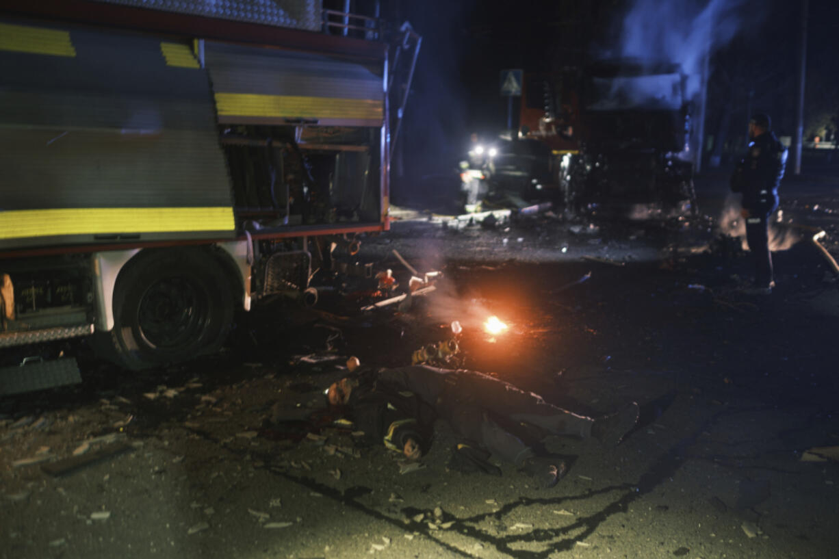 EDS NOTE: GRAPHIC CONTENT - The dead body of rescue worker lies on the ground after Russian drone strikes on residential neighborhood in Kharkiv, Ukraine, on Thursday, April. 4, 2024.