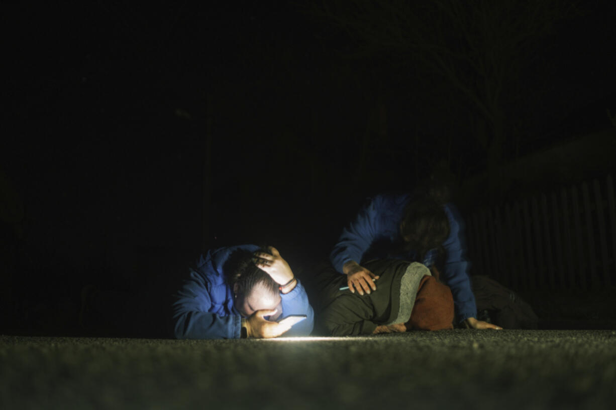 Local residents take cover during a Russian drone strike on residential neighborhood in Kharkiv, Ukraine, on Thursday, April. 4, 2024.