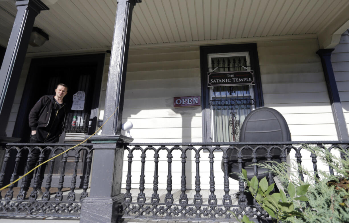 FILE - A person stands on the porch of the international headquarters of the Satanic Temple in Salem, Mass., Oct. 24, 2016. Someone threw an explosive device onto the porch of The Satanic Temple in Massachusetts at a time when no one was inside, and the device and damage it caused were not found until nearly 12 hours later, police said. No injuries were reported. State police bomb technicians ensured that the device was no longer a danger, police said in a news release Monday, April 8, 2024.