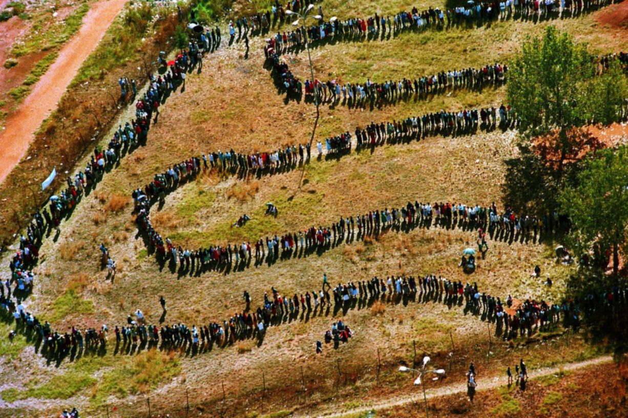 FILE - People queue to cast their votes In Soweto, South Africa April 27, 1994, in the country&rsquo;s first all-race elections. In 1994 people braved long queues to cast a vote after years of white minority rule which denied Black South Africans the vote. (AP Photo/Denis Farrell.