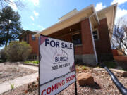 A for sale sign stands outside a home on April 3 in Denver.