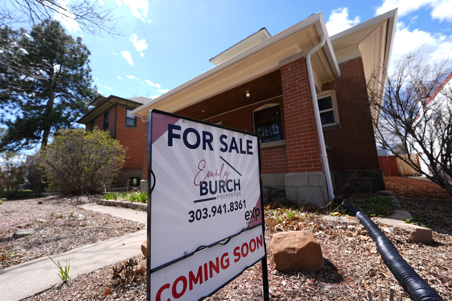 A for sale sign stands outside a home on April 3 in Denver.