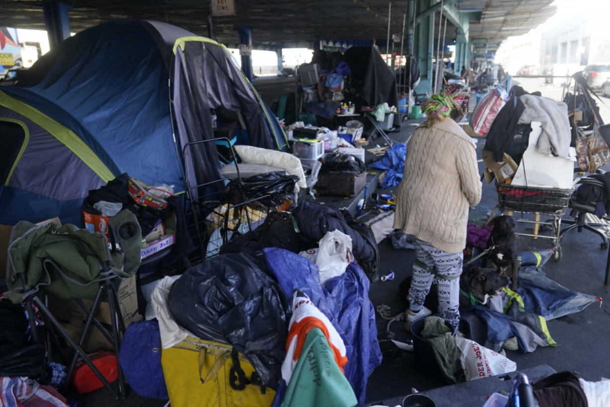 FILE - A woman gathers possessions to take before a homeless encampment was cleaned up in San Francisco, Aug. 29, 2023. The Supreme Court will hear its most significant case on homelessness in decades Monday, April 22, 2024, as record numbers of people in America are without a permanent place to live. The justices will consider a challenge to rulings from a California-based federal appeals court that found punishing people for sleeping outside when shelter space is lacking amounts to unconstitutional cruel and unusual punishment.