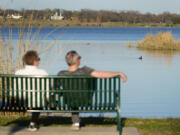 FILE - A couple sit along a trail overlooking White Rock Lake in Dallas on Feb. 24, 2024. Coming up with the best tax strategy in retirement can be much trickier than it seems, and tax pros agree that it is a time when people need to be especially careful.