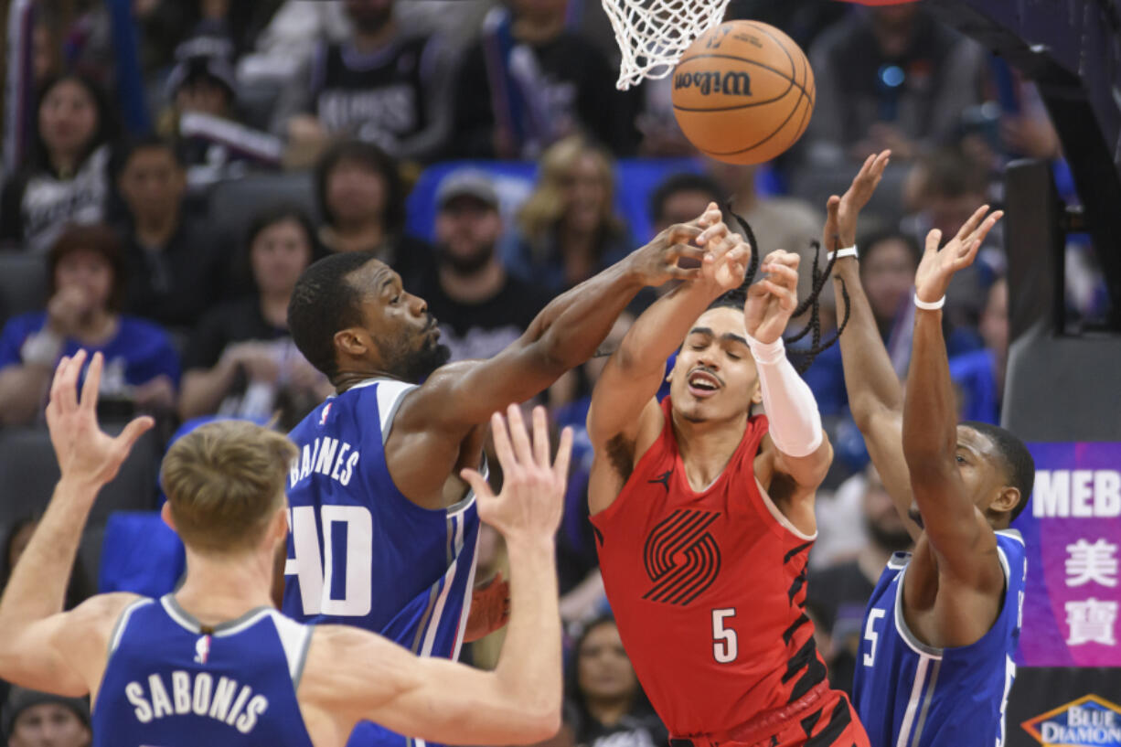 Sacramento Kings forward Harrison Barnes, left, and Portland Trail Blazers guard Dalano Banton (5) battle for a rebound during the second half of an NBA basketball game in Sacramento, Calif., Sunday, April 14, 2024.